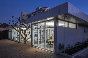 los angeles hollywood arri education center modern sustainable prefabricated steel frame bluesky building systems insulated metal panel office exterior entry built around plumeria tree night copy 1 300x200